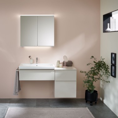 Kupaonica s kupaonskim namještajem, umivaonikom i elementom s ogledalom proizvođača Geberit ispred pastelnog zida