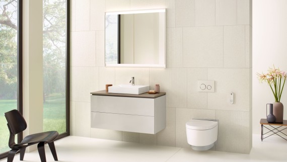 Bijela kupaonica s elementom s ogledalom, bazom za umivaonik, tipkom za aktiviranje i sanitarnom keramikom proizvođača Geberit