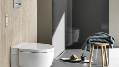 Geberit AquaClean Mera Comfort tuš WC uređaj s daljinskim upravljačem i Sigma50 tipkom za aktiviranje (© Geberit)